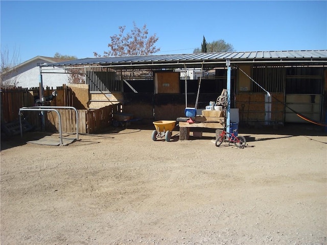 back of house featuring metal roof, an exterior structure, and an outdoor structure