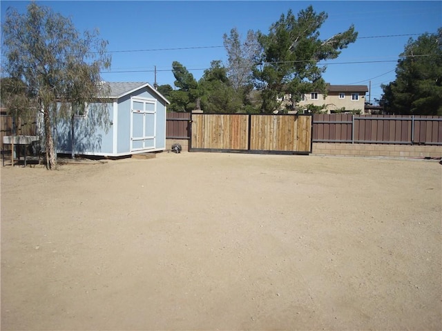 view of yard with fence, an outdoor structure, and a storage shed