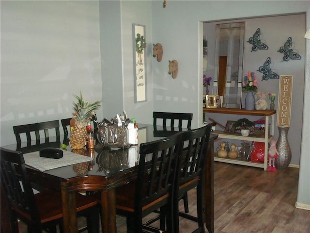 dining area with baseboards and wood finished floors