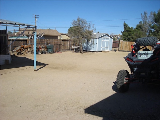 view of yard featuring a shed, fence, and an outdoor structure