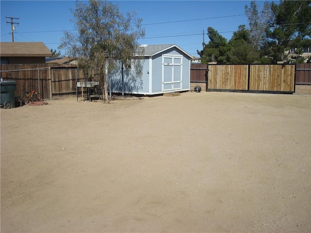 view of yard with a storage shed, a fenced backyard, and an outdoor structure