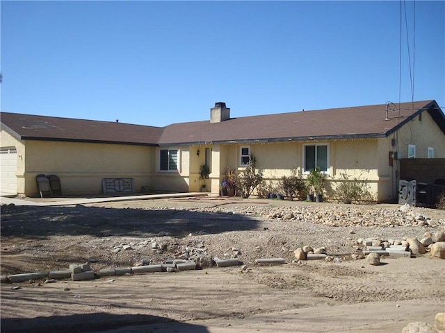 view of front facade with a garage and a chimney