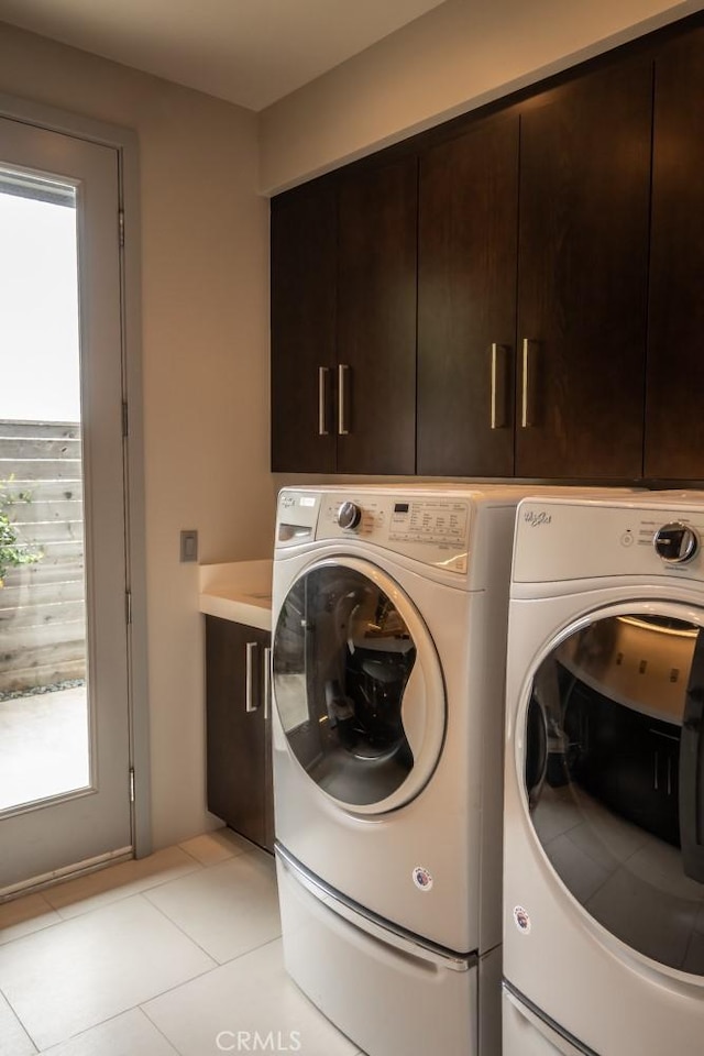 washroom with cabinet space, light tile patterned floors, and independent washer and dryer