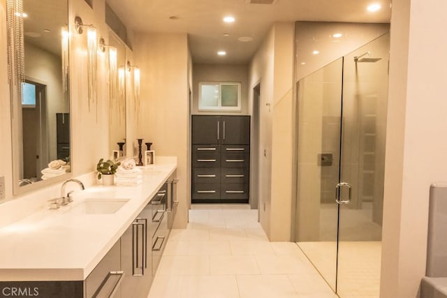 bathroom with double vanity, a stall shower, a sink, and tile patterned floors