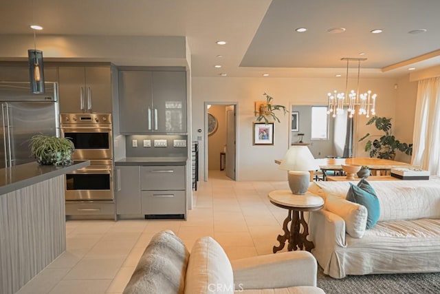 living room featuring a chandelier, recessed lighting, a raised ceiling, and light tile patterned flooring