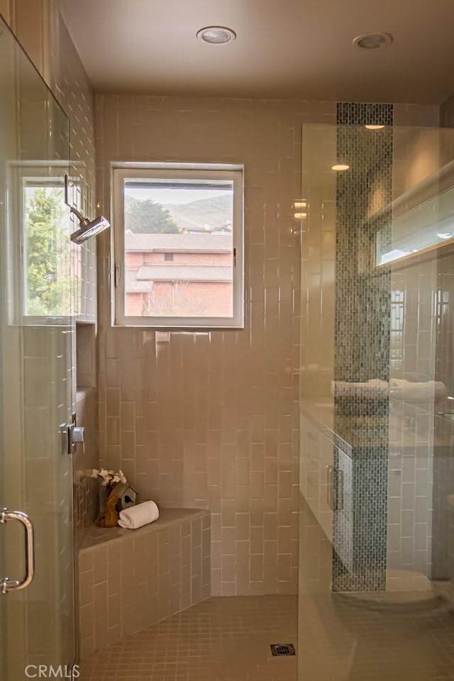 full bathroom featuring plenty of natural light, a shower stall, and tile patterned flooring