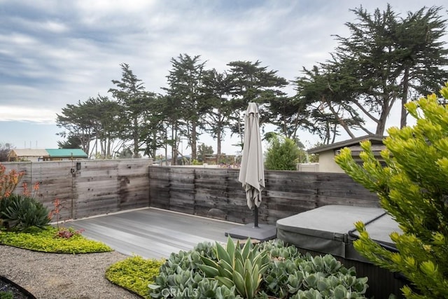 view of community with a hot tub and a fenced backyard