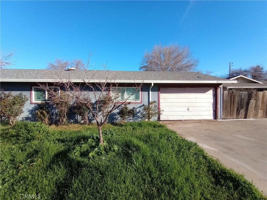 single story home featuring an attached garage, fence, and concrete driveway