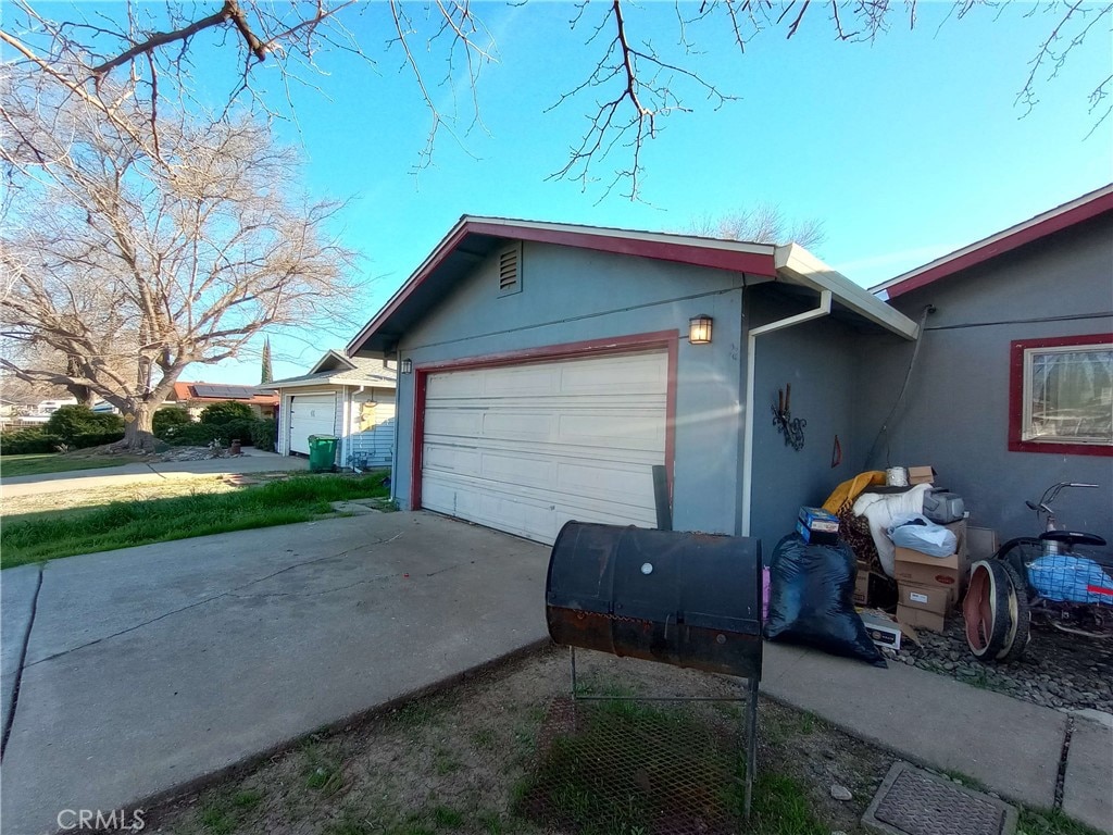 view of property exterior featuring a garage, concrete driveway, and stucco siding