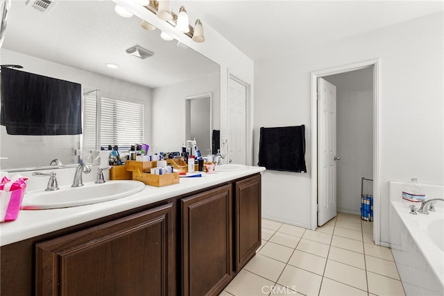 bathroom featuring a garden tub, double vanity, a sink, and visible vents