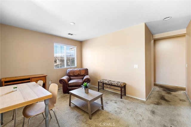 living area featuring carpet floors, visible vents, and baseboards