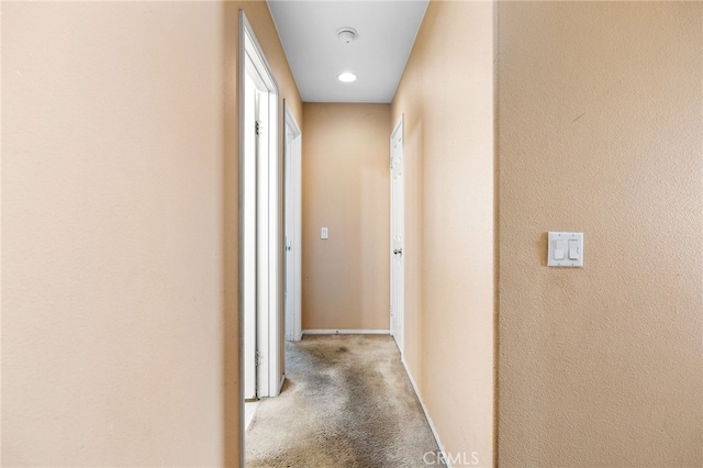 corridor with carpet and baseboards