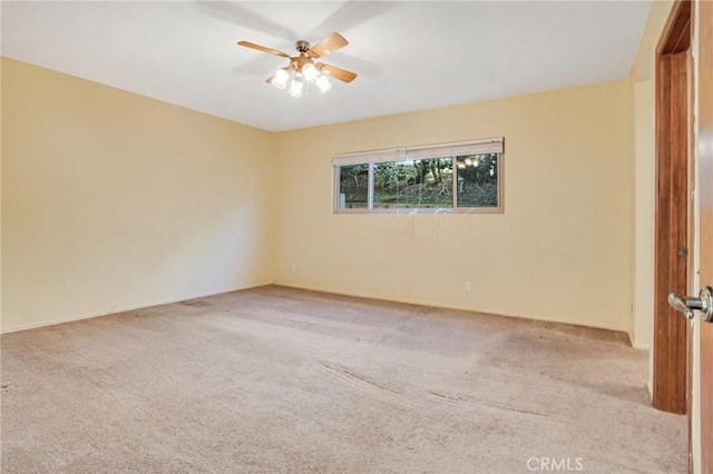 spare room featuring carpet flooring, ceiling fan, and baseboards