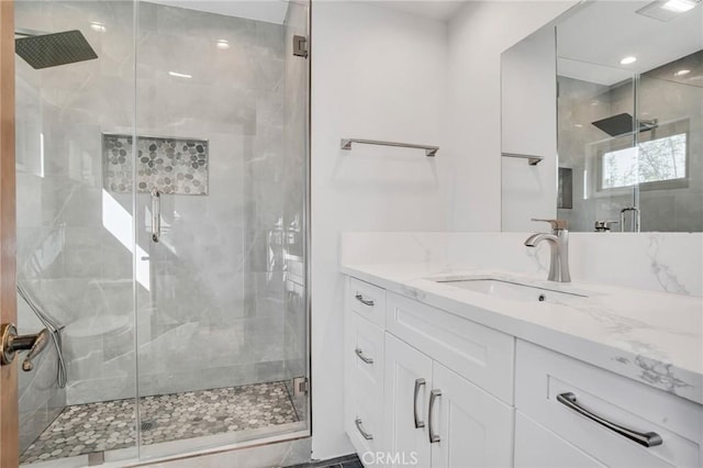 bathroom with a shower stall and vanity