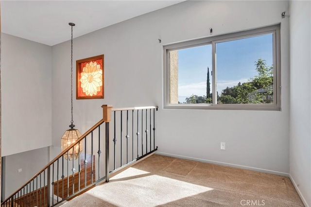 carpeted spare room featuring baseboards
