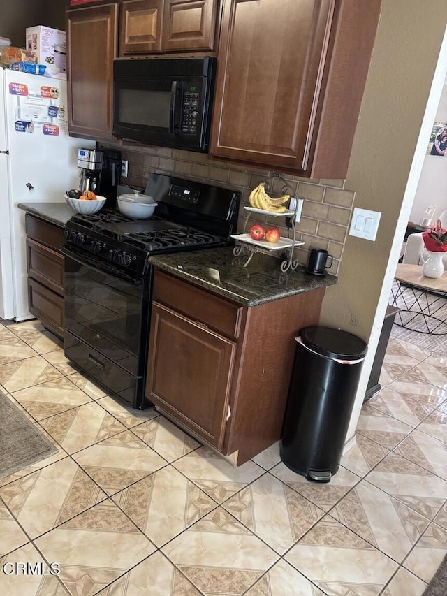 kitchen featuring black appliances, tasteful backsplash, and dark stone counters