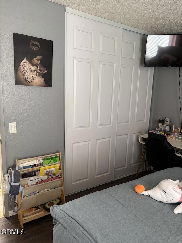 bedroom featuring dark wood-style floors and a textured ceiling