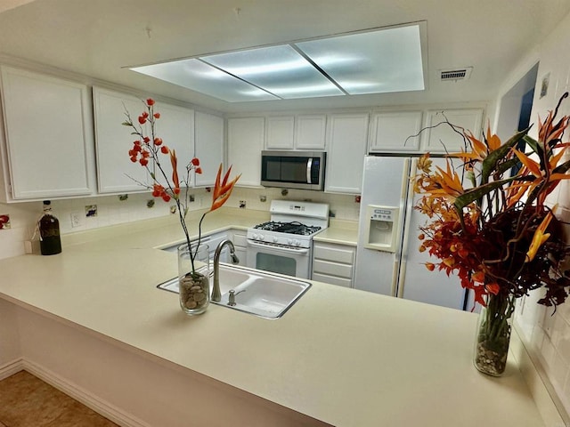 4741 Sequoia Pl, Oceanside, CA 92057 - kitchen with white appliances, a sink, a peninsula, light countertops, and white cabinets