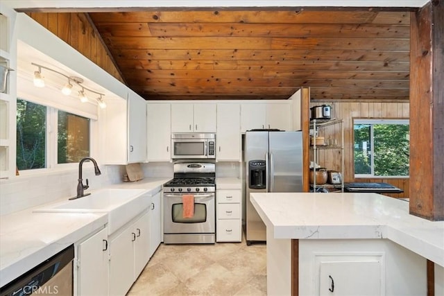 kitchen featuring wooden ceiling, stainless steel appliances, white cabinets, vaulted ceiling, and tasteful backsplash