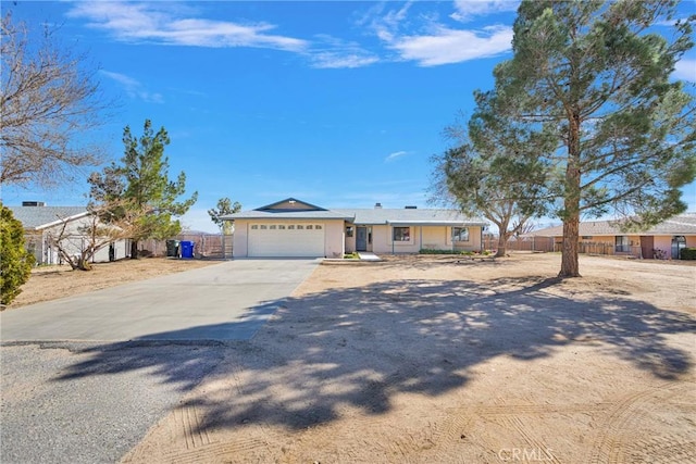 ranch-style house with a garage, concrete driveway, and fence