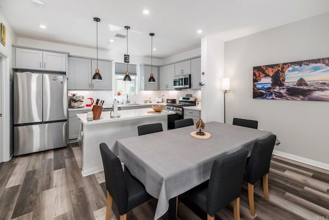 dining space featuring dark wood-type flooring, recessed lighting, visible vents, and baseboards