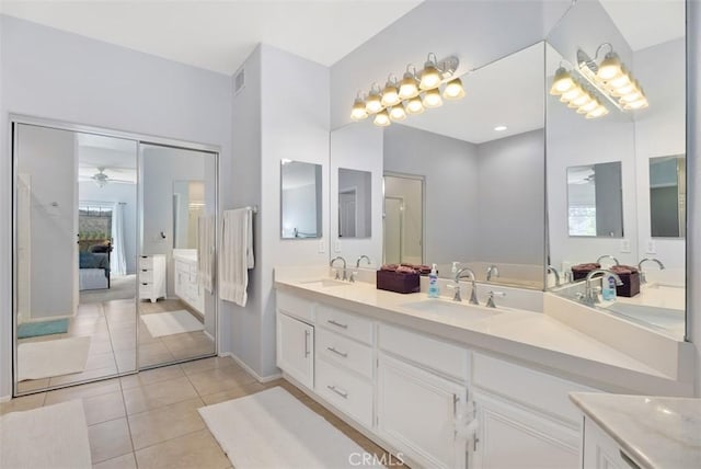 ensuite bathroom featuring double vanity, a sink, connected bathroom, and tile patterned floors