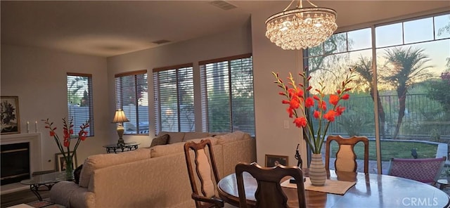 dining space featuring a fireplace, visible vents, and a notable chandelier