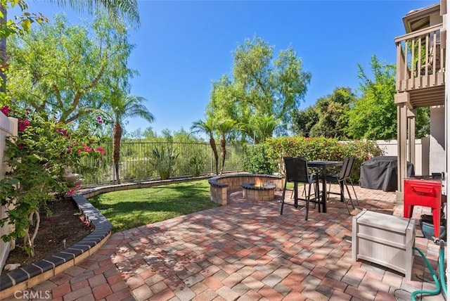 view of patio / terrace with a fenced backyard, a fire pit, and grilling area