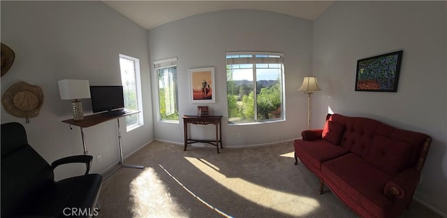 carpeted living area featuring vaulted ceiling and baseboards