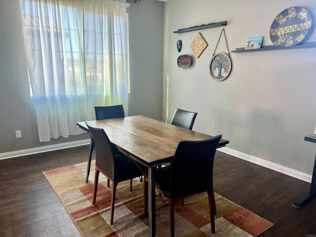 dining space with wood finished floors and baseboards