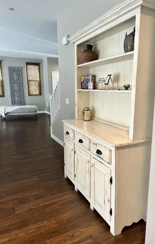 interior space with stairway, dark wood-style flooring, and baseboards