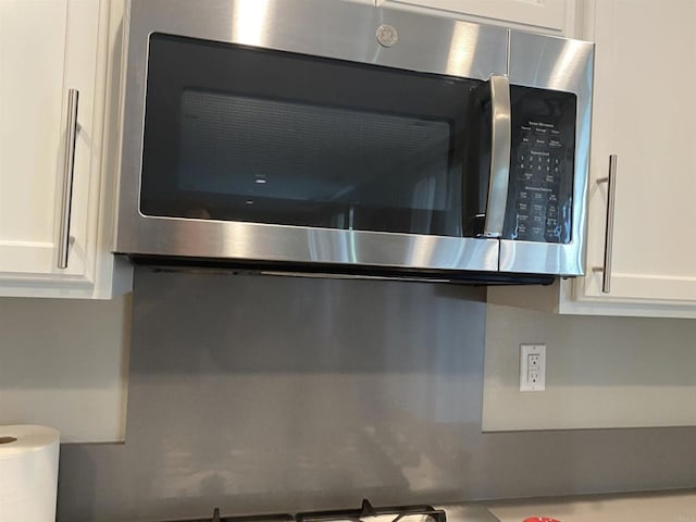 room details with stainless steel microwave and white cabinetry