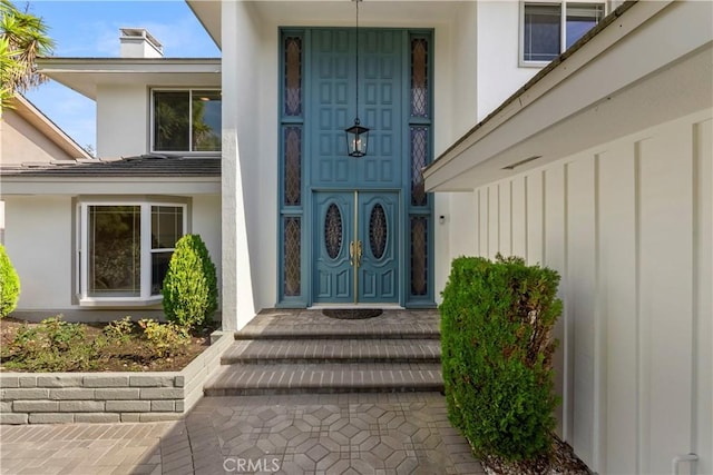 view of exterior entry with stucco siding