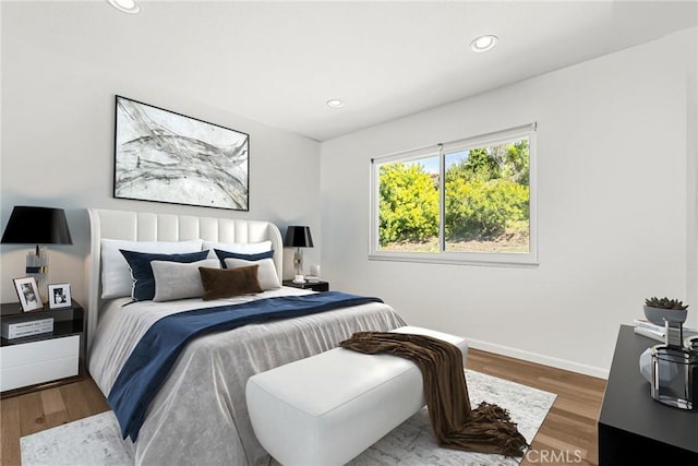 bedroom with baseboards, wood finished floors, and recessed lighting