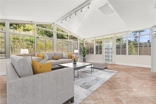 sunroom with vaulted ceiling and track lighting