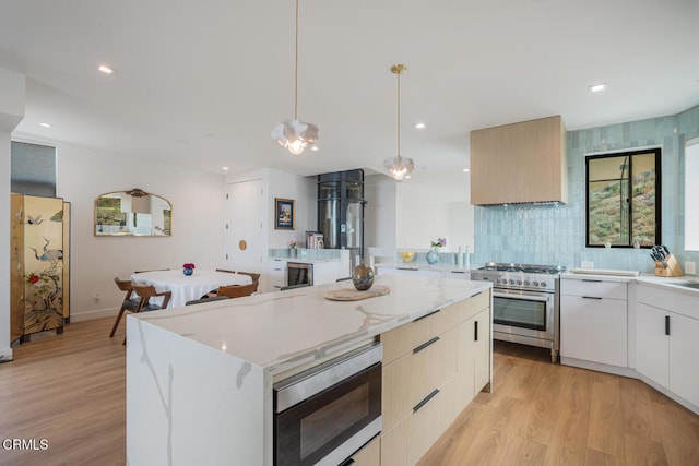 kitchen with a center island, stainless steel appliances, light wood-style flooring, modern cabinets, and premium range hood