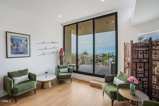 sitting room featuring a wall of windows and wood finished floors