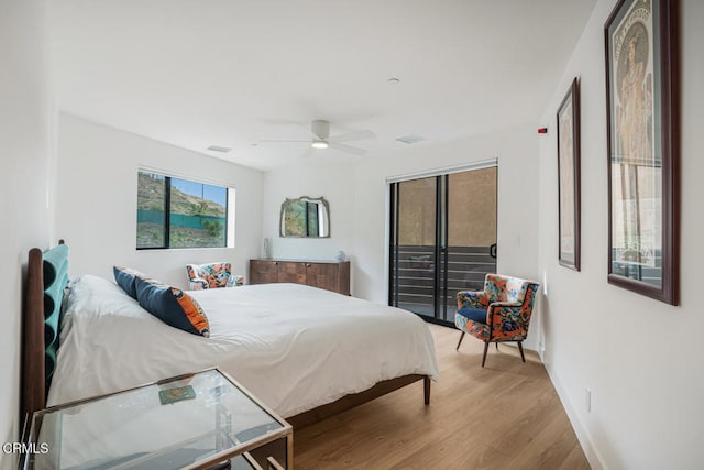 bedroom featuring wood finished floors, visible vents, a ceiling fan, baseboards, and access to outside