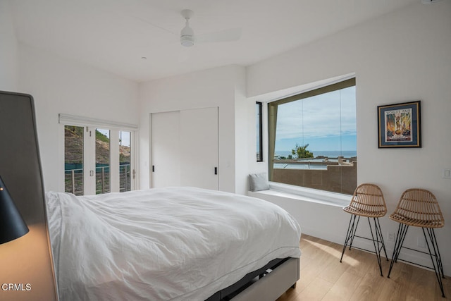 bedroom featuring access to outside, wood finished floors, and a ceiling fan