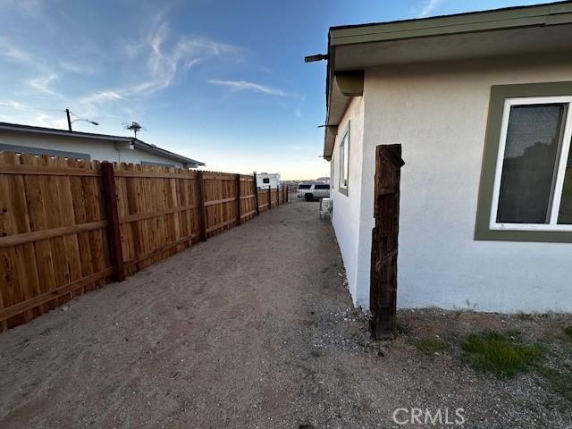 view of side of property featuring fence and stucco siding