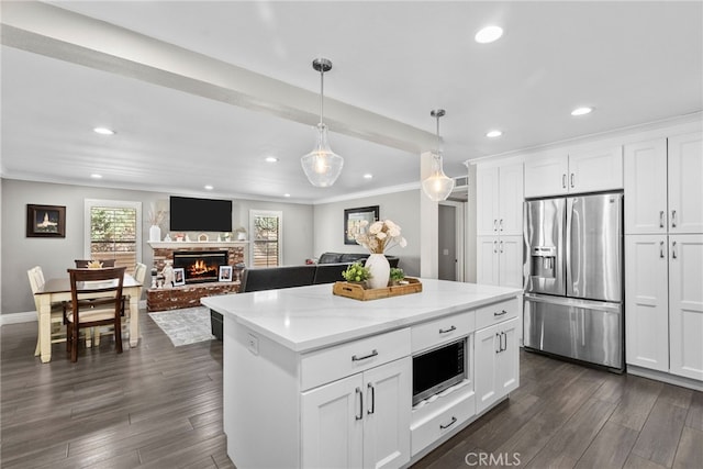 kitchen featuring ornamental molding, stainless steel appliances, dark wood-type flooring, and a lit fireplace