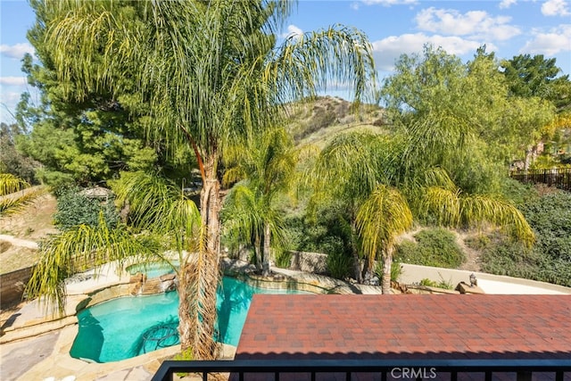 outdoor pool with an in ground hot tub and a patio