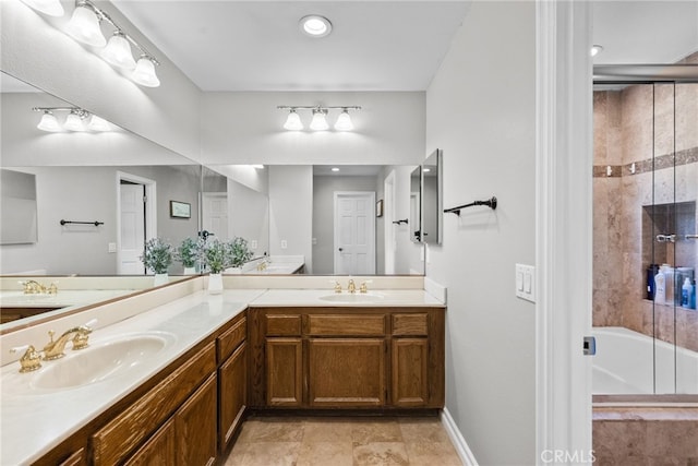 bathroom with double vanity, combined bath / shower with glass door, and a sink