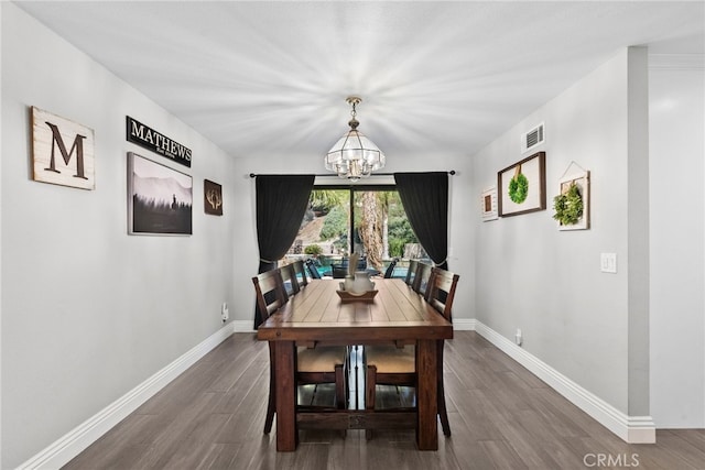 dining area with visible vents, a notable chandelier, baseboards, and wood finished floors