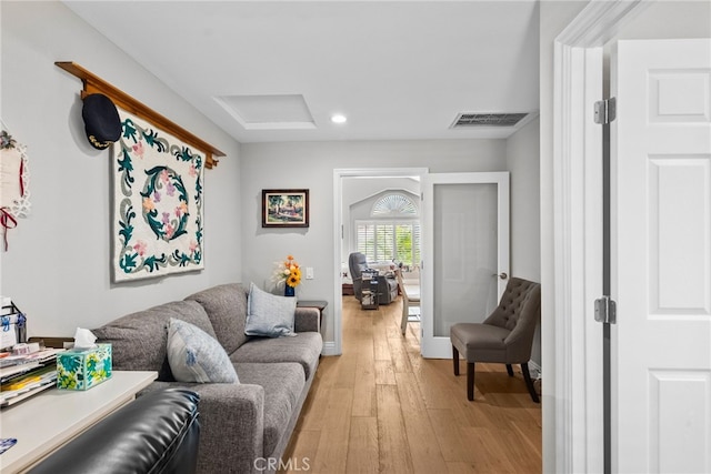 living area featuring light wood finished floors, attic access, visible vents, and recessed lighting