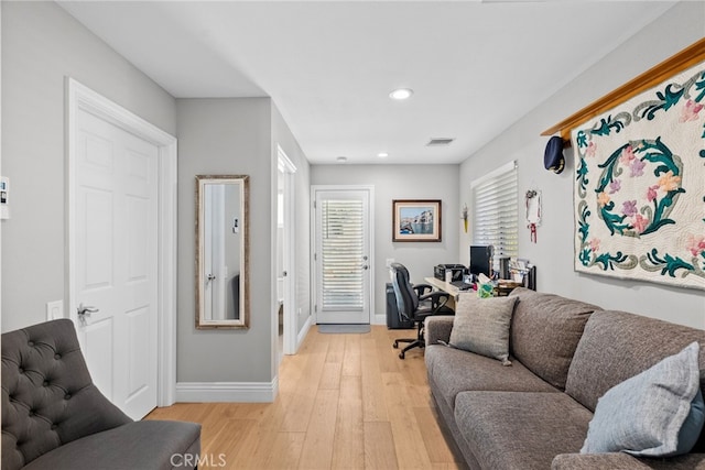 living area featuring light wood-style floors, baseboards, visible vents, and recessed lighting