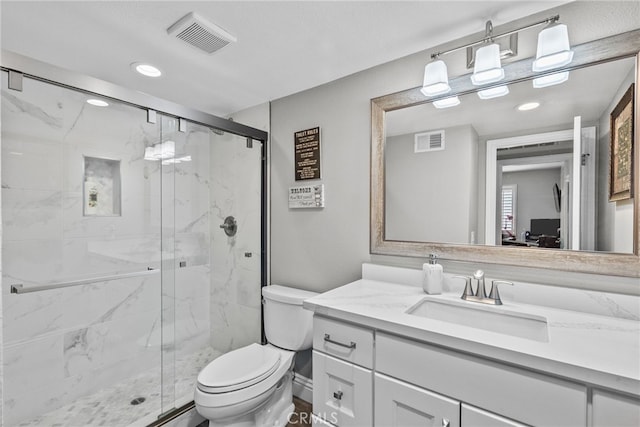 full bath with toilet, vanity, a marble finish shower, and visible vents