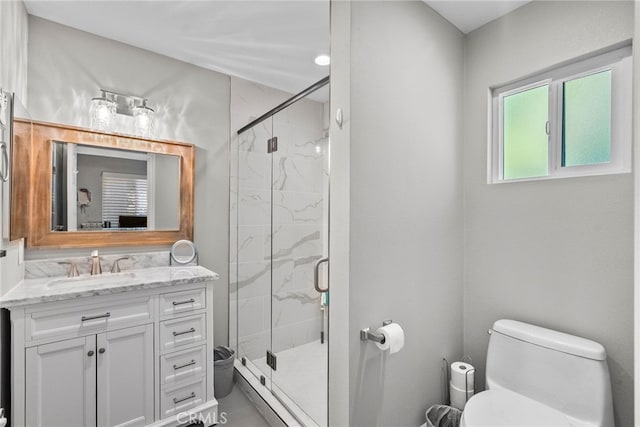 bathroom with toilet, a shower stall, and vanity