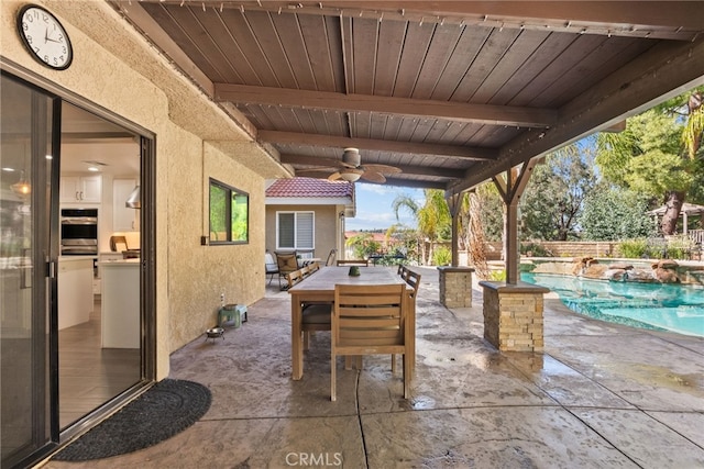 view of patio with a fenced in pool, outdoor dining area, and a ceiling fan