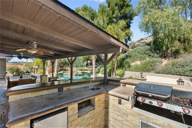 view of patio with ceiling fan, a grill, an outdoor kitchen, and a sink